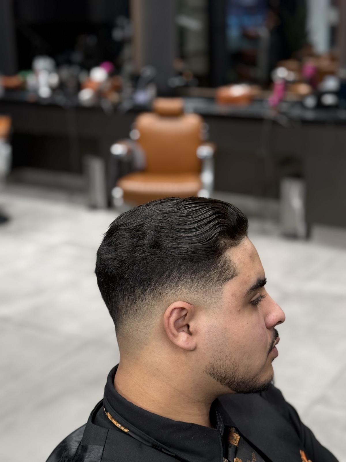 Low skin fade with a slicked back finish