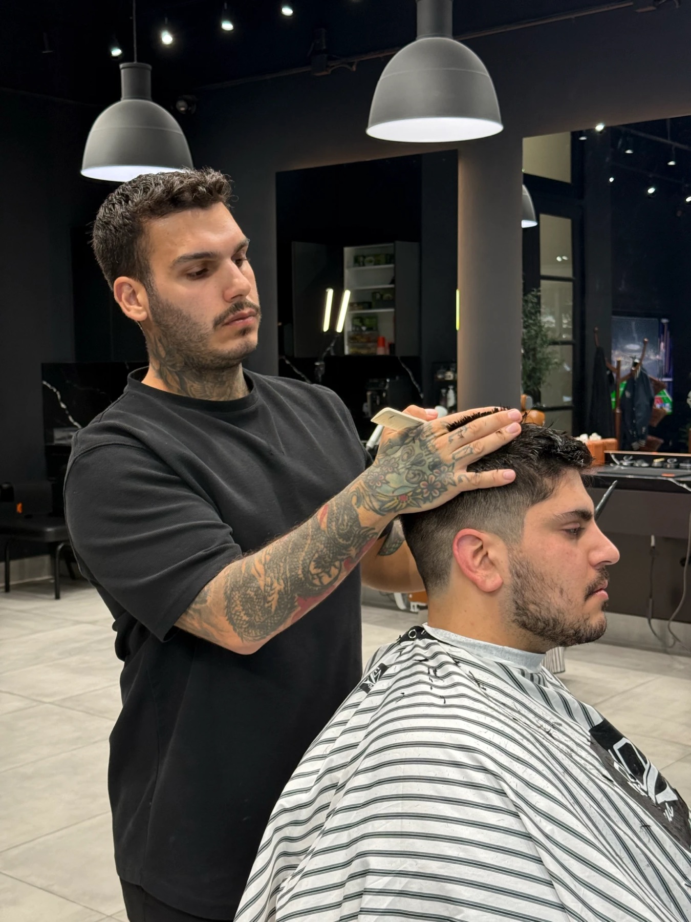 Jacob shaping a client's fade at Rendezvous Barbershops, King and Bathurst